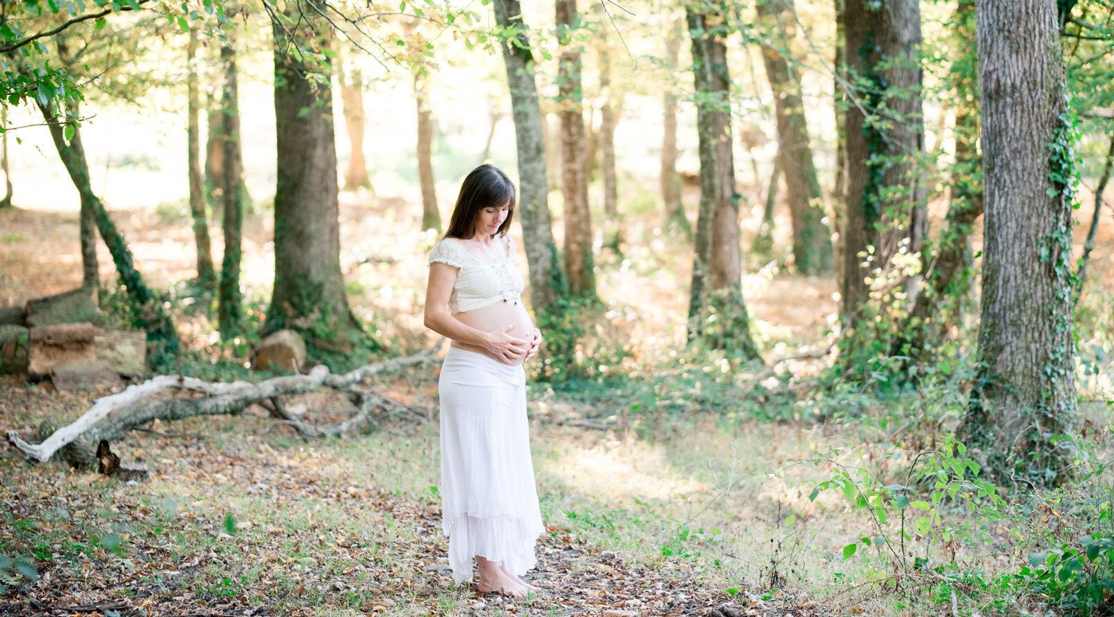 Femme enceinte entourée d'arbres dans une forêt