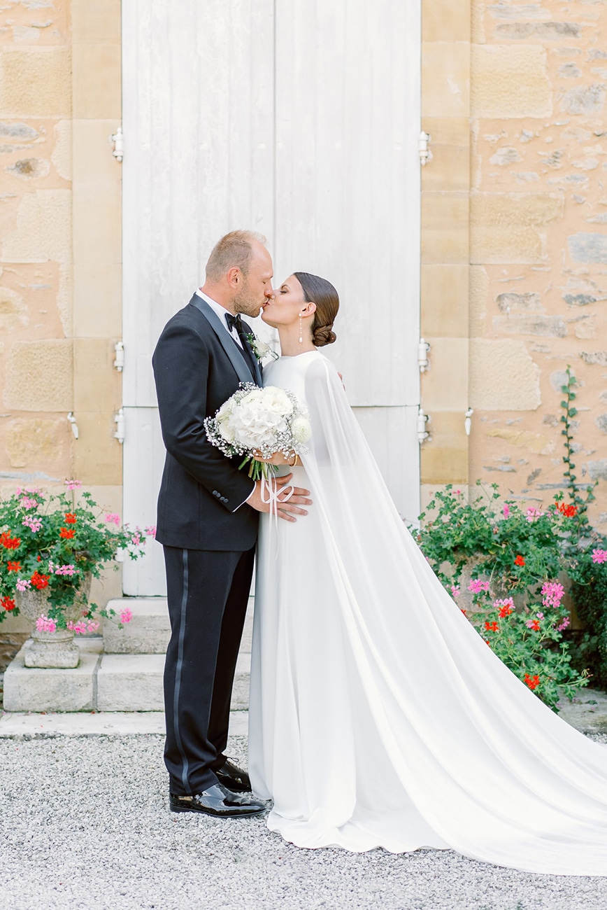 eloise-james-essendieras Bride and groom sharing a kiss in front of a white door at Domaine d'Essendieras