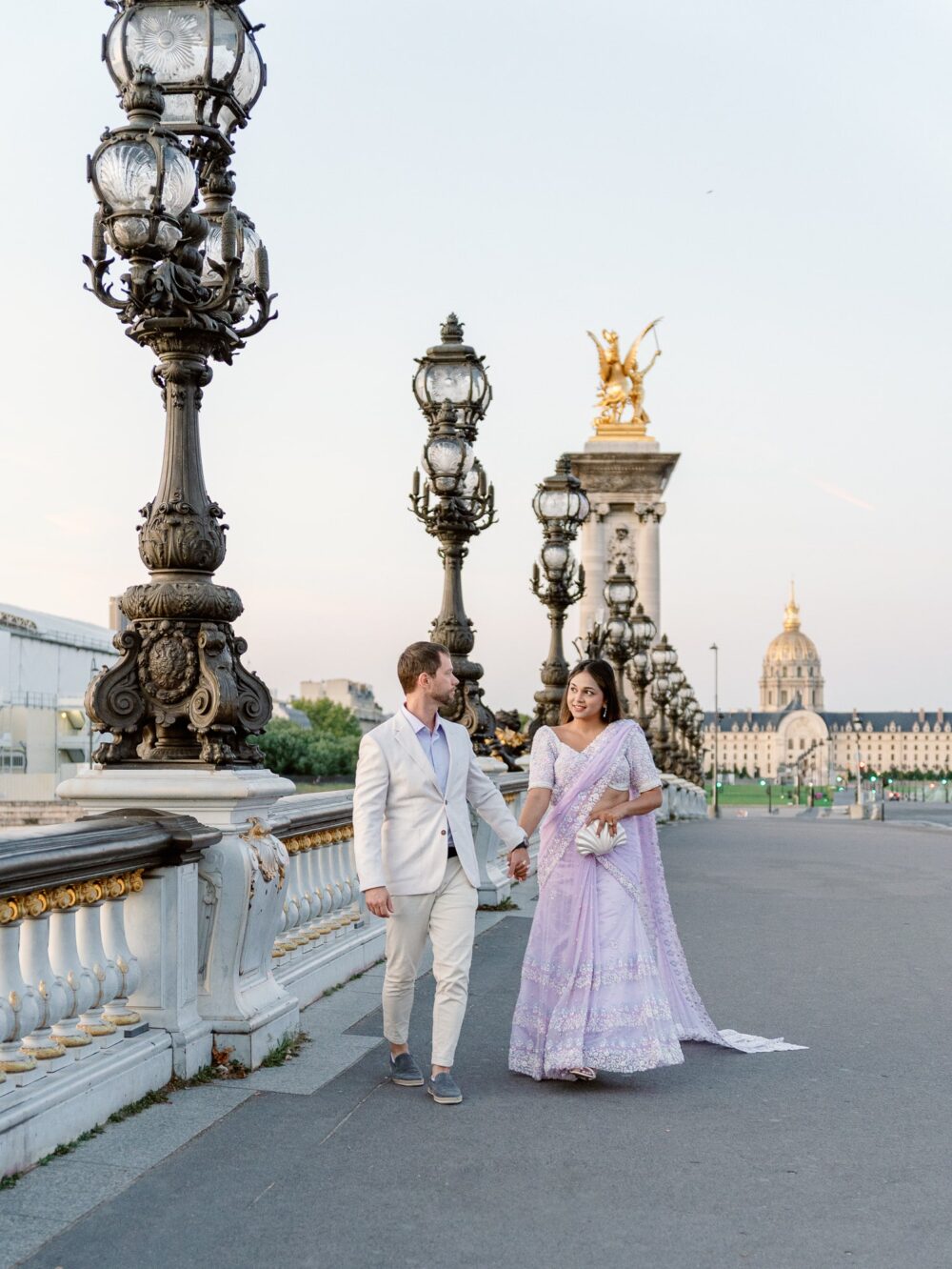 a couple walking on pont alexandre II in Paris at sunrise