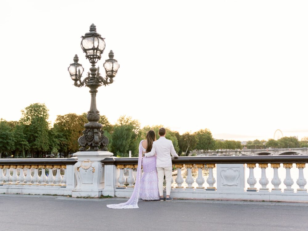 The couple looking t the seine from the bridge