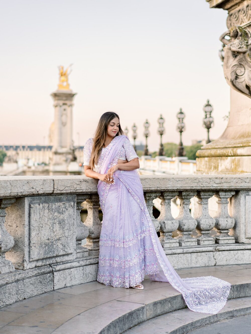 woman on the pont alexandre III in paris in a purple sari