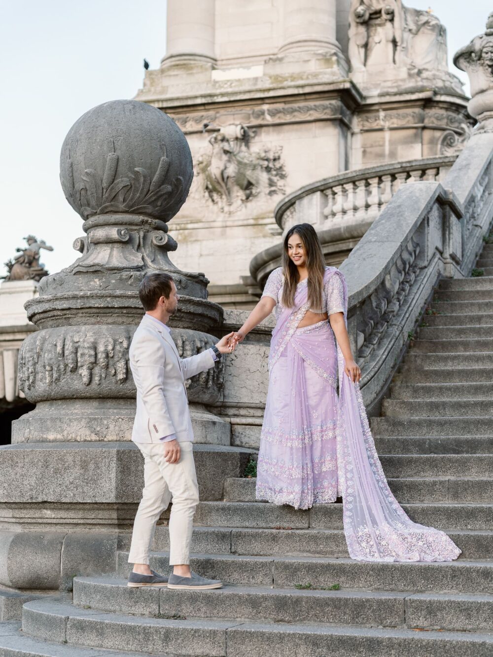 eugene holding Poorva's hand in the staircase of Pont Alexandre III