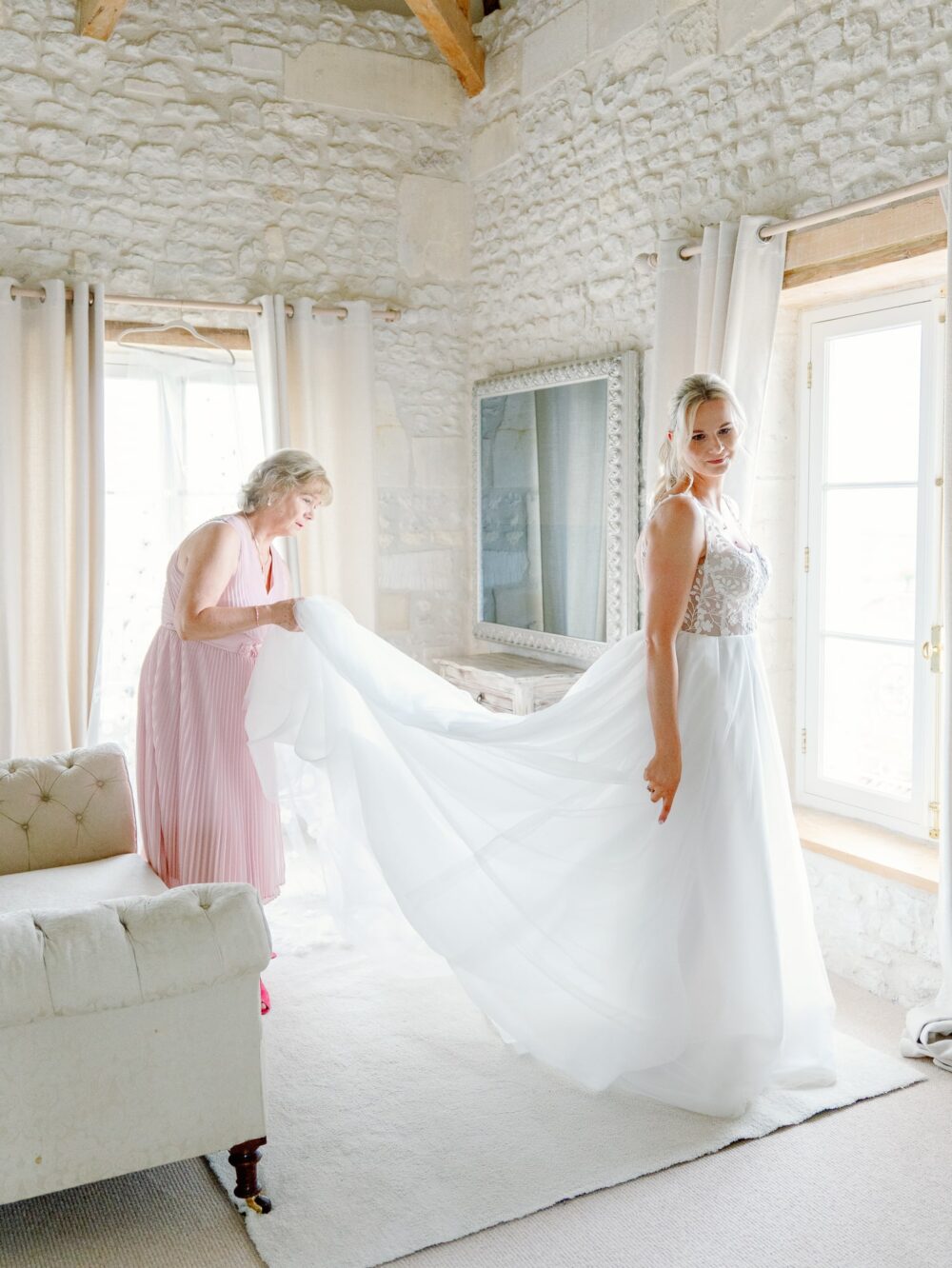 The mother of the Bride helping her getting dressed