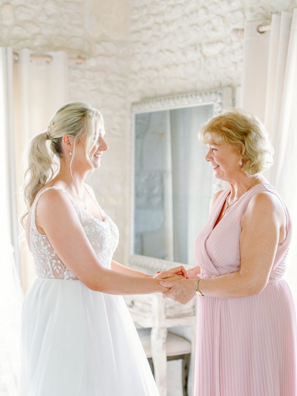 The bride and her mother holding hands