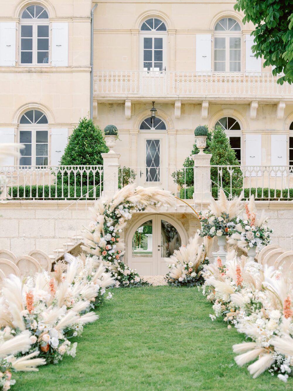 Lush wedding ceremony in beige, blush, pink, peaches tones with a rounded arch