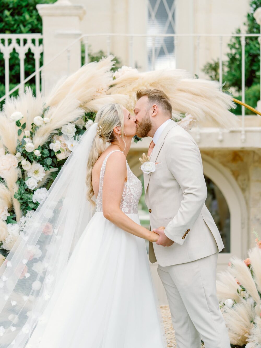Bride and groom kissing in front of the wedding arch