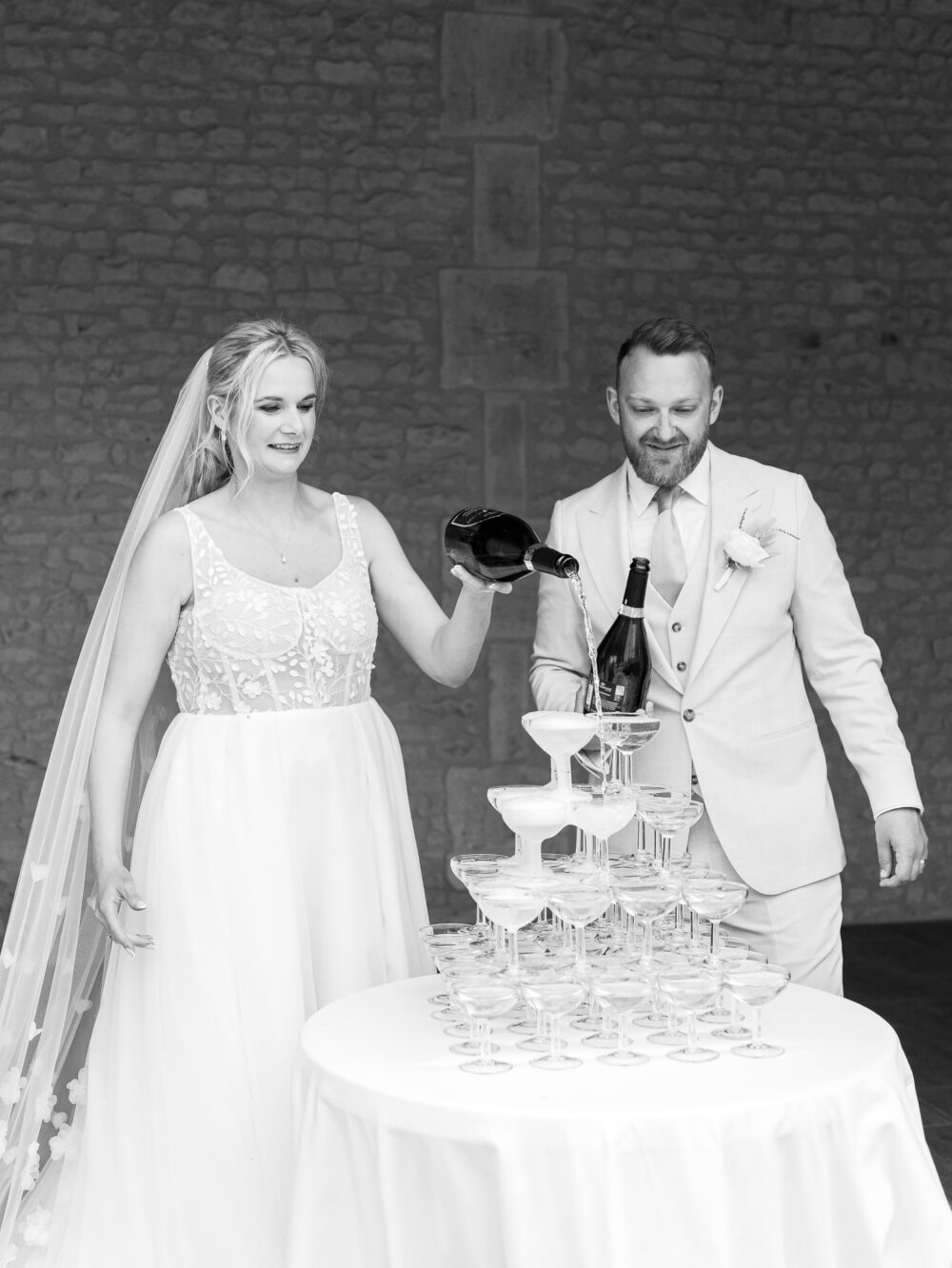 Bride and groom in front of champagne tower