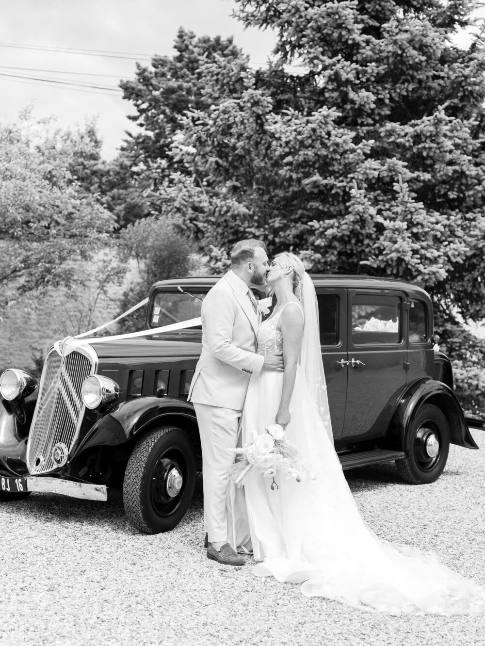 Bride and groom in front of the car