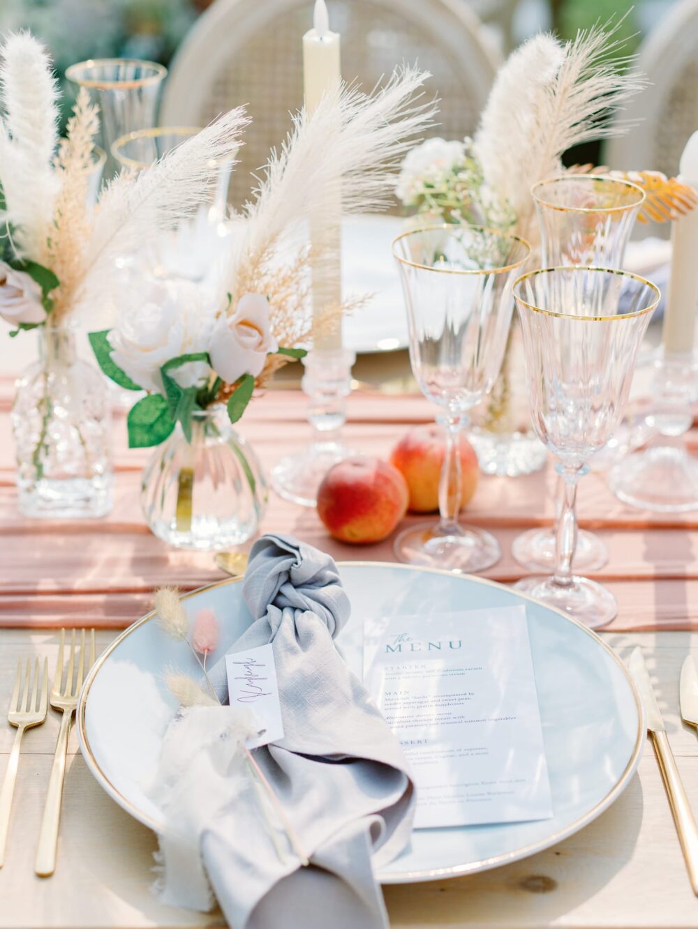 place with a plate and golden cutlery and peaches and flowers