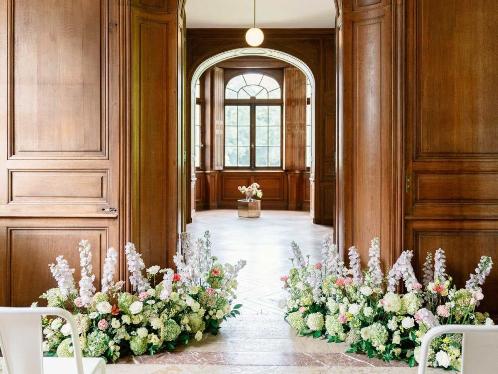Wedding ceremony inside Chateau de Thauvenay with flowers on the ground