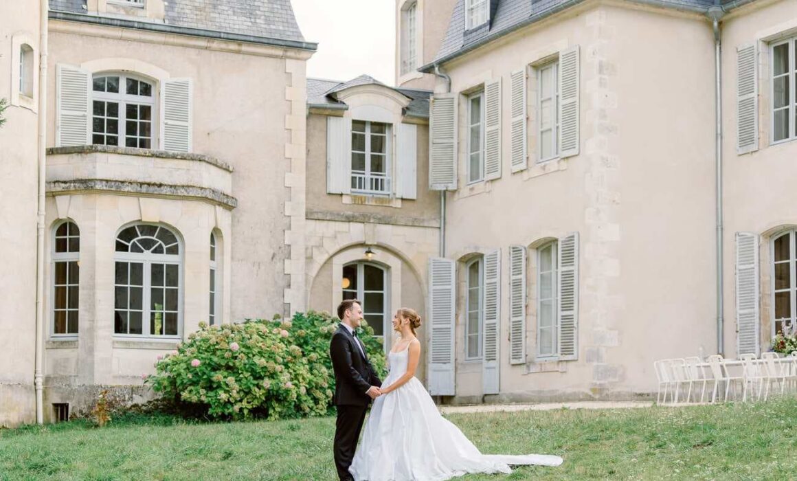 portrait of the bride and groom in front of Chateau de Thauvenay