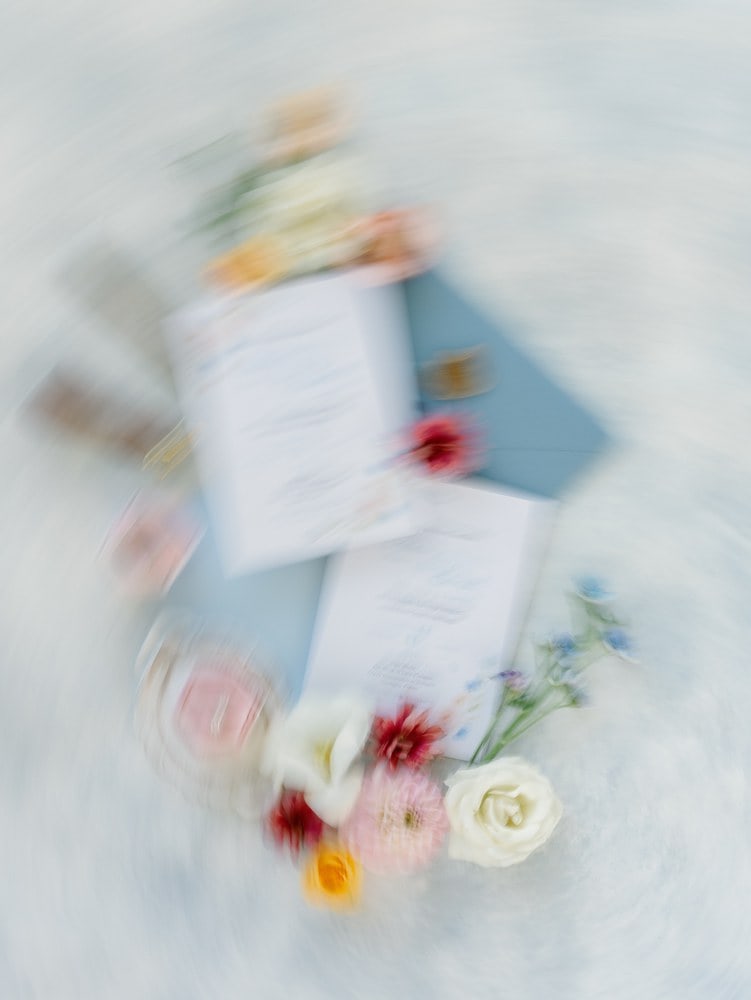 blurry flatlay of wedding invitations