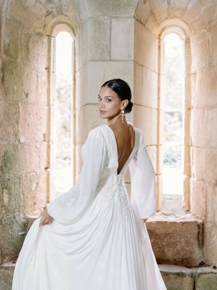 Bride in front of stone wall with a white dress