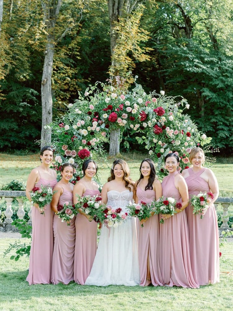 Bride with her bridesmaids with pink dresses and magenta/bordeaux flowers