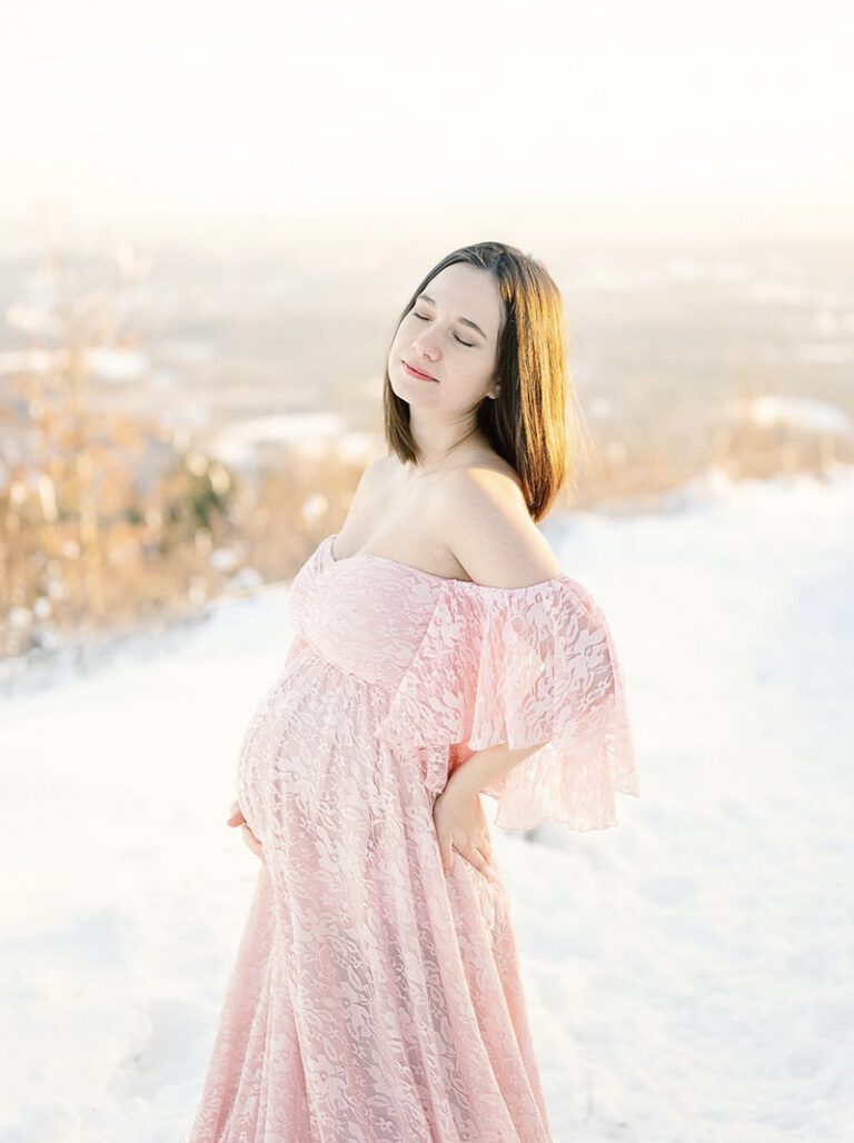 Femme enceinte dans une robe rose dans la neige