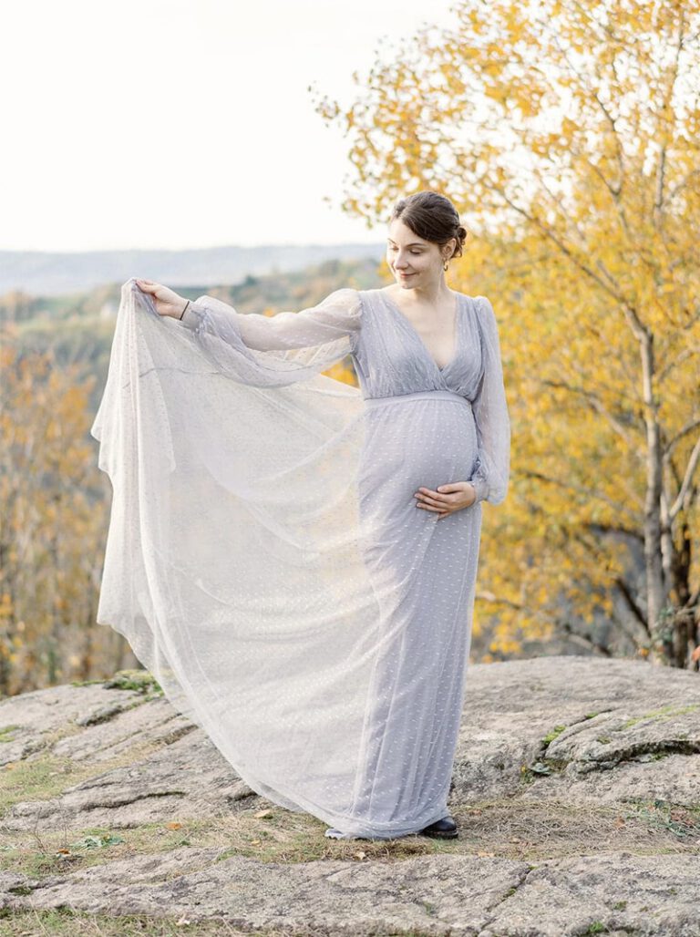 Femme enceinte en robe grise dans un décor automnal