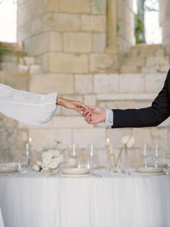 Bride and groom holding hands in an abbey