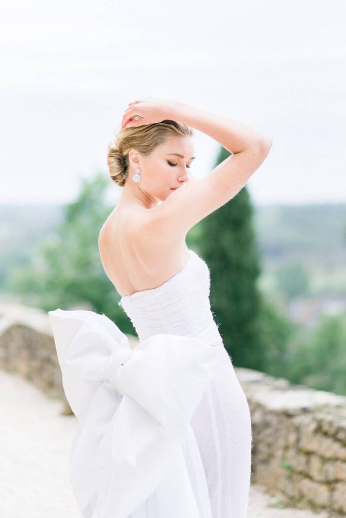portrait d'une mariée avec un noeud au dos de sa robe blanche