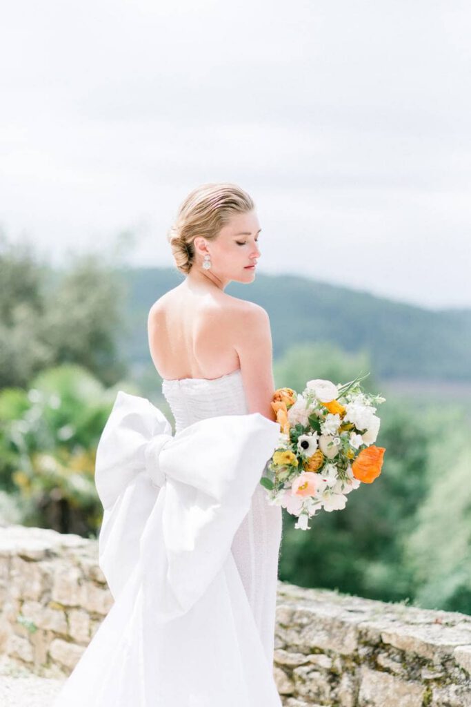 portrait d'une mariée avec un noeud au dos de sa robe blanche