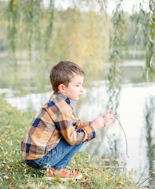 Enfant avec une chemise à carreau au bord de l'eau d'un lac