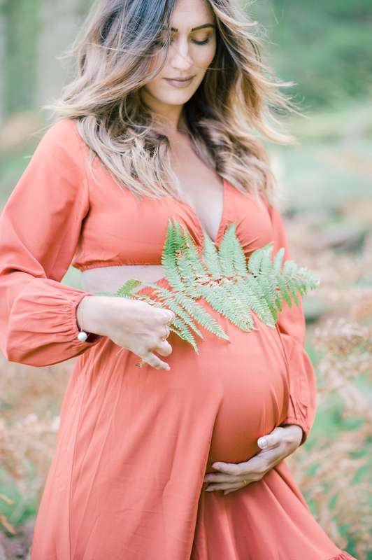 Femme enceinte avec une fougère sur son ventre
