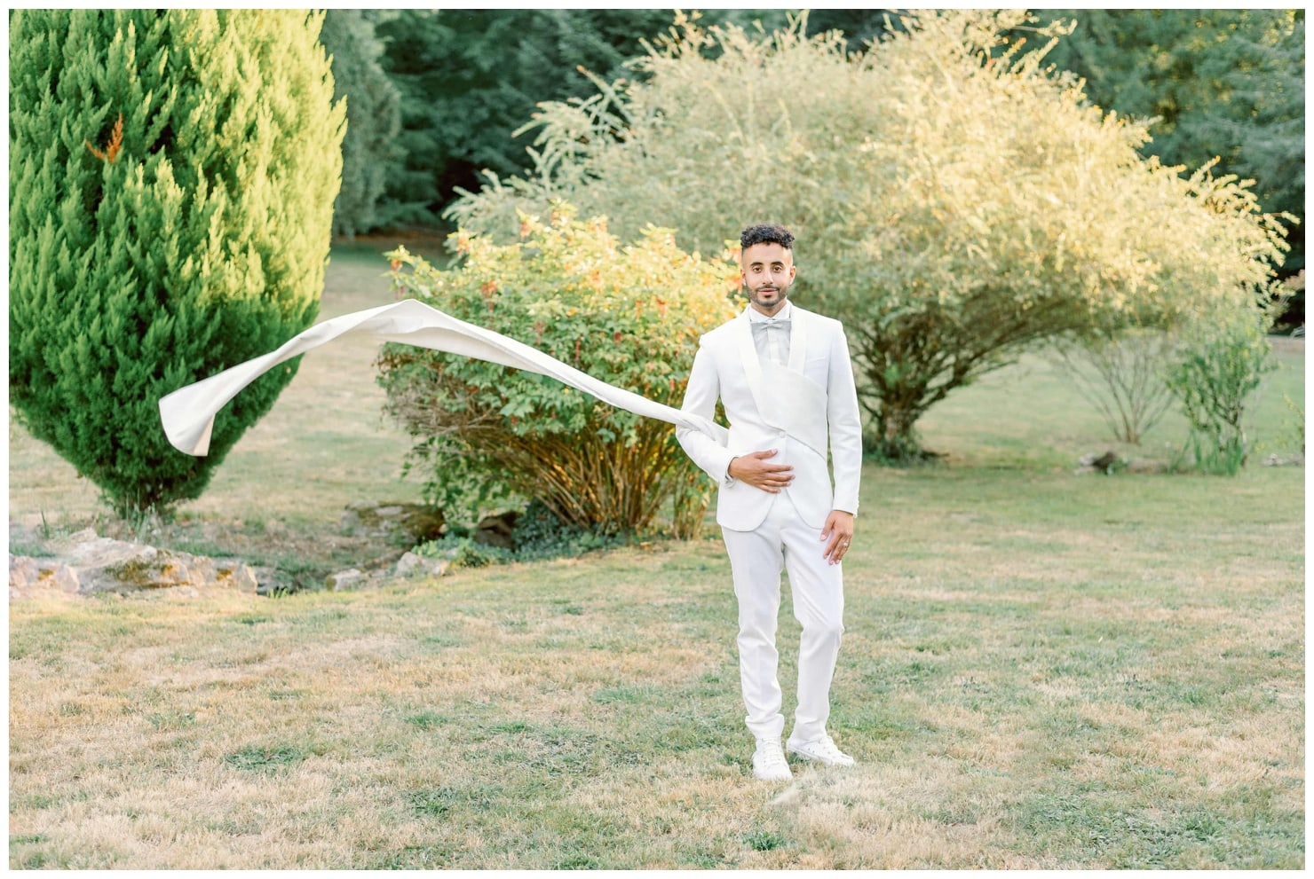 marié en costume blanc avec une traine