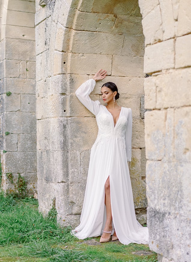 bride wearing a white gown in an old abbey in france
