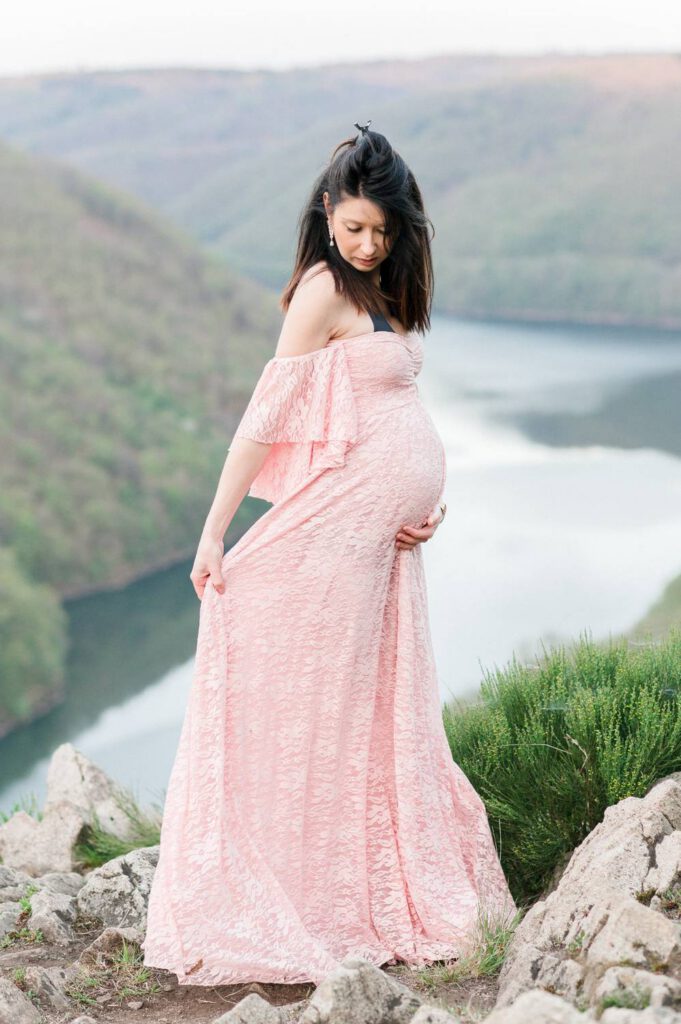 femme enceinte en robe rose devant une rivière