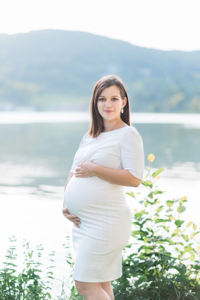 femme enceinte en robe blanche au bord du lac