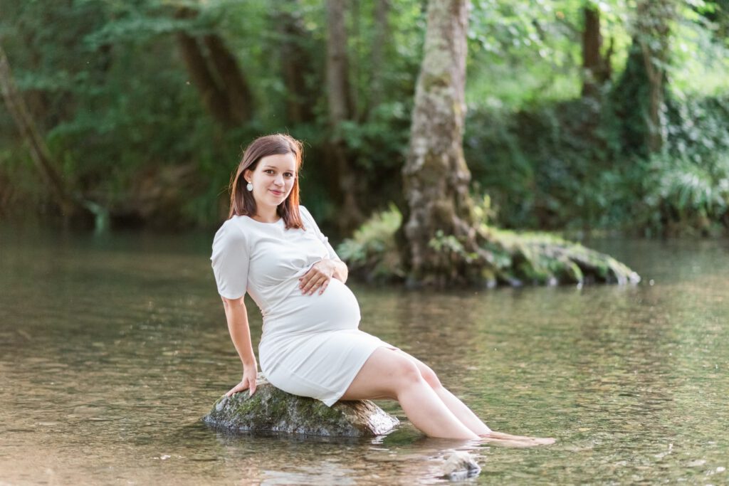 femme enceinte en robe blanche au milieu de la rivière