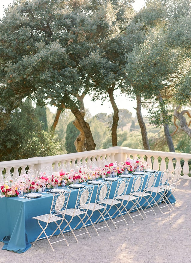 wedding table in the south of france with a blue petrol tablecloth and magenta flowers