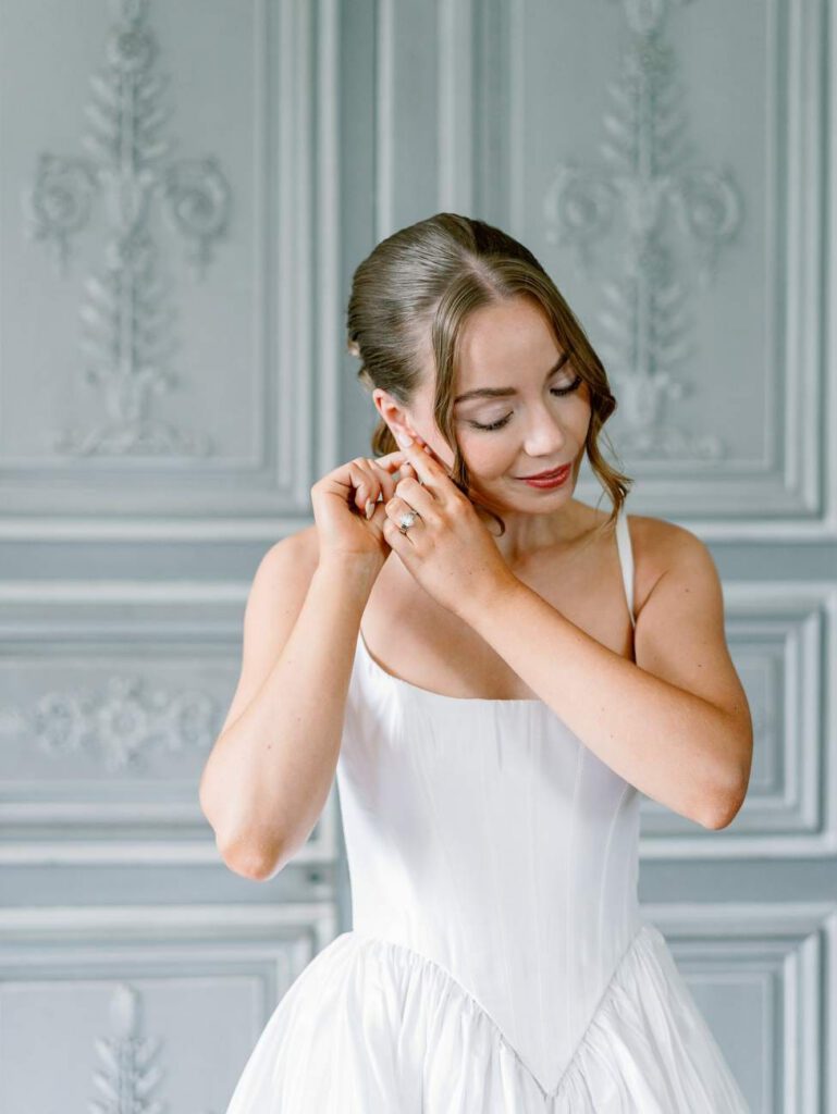 Bride putting on her earrings