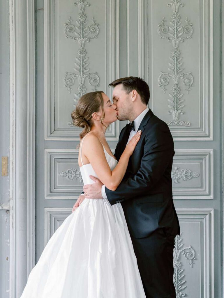 Bride and groom kiss in a french room
