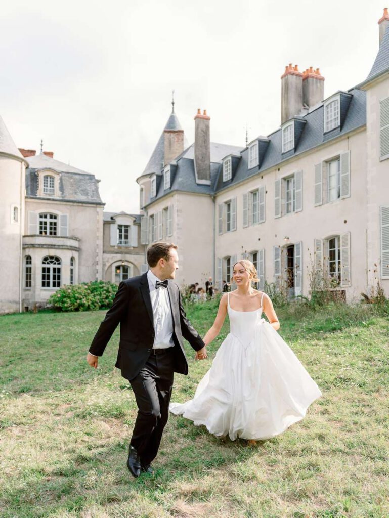Bride and groom running in the gardens of Château de Thauvenay
