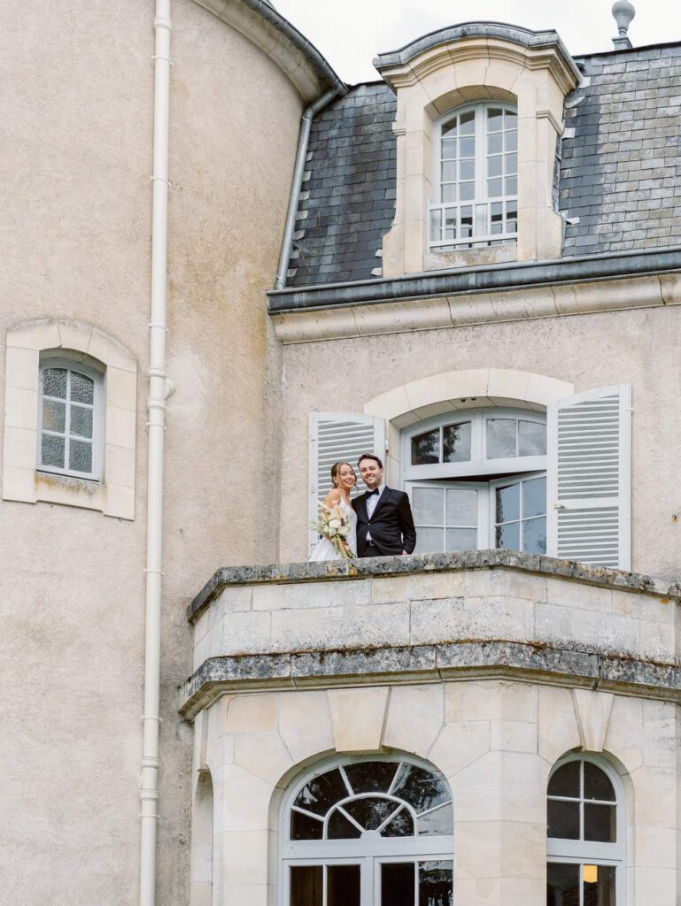 Bride and groom in a balcony of château de thauvenay