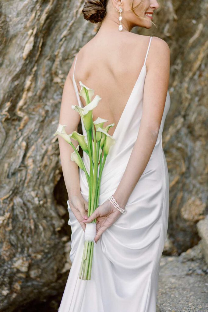 bride with a bouquet of arums in the back
