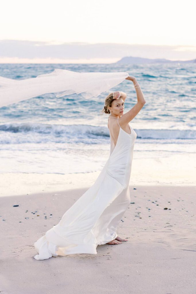 bride with her veil at the beach