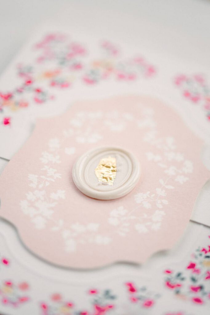 Wedding invitation in pink with a white wax seal