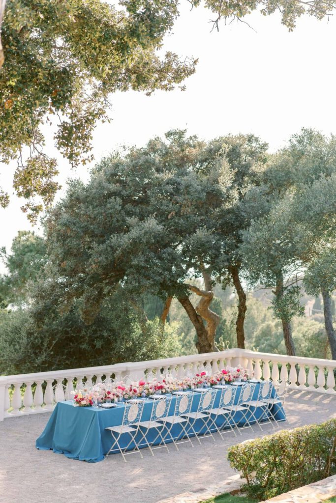 Blue wedding table with fushia flowers at castel bay