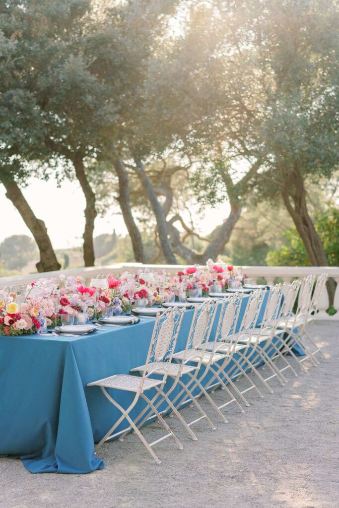 Blue wedding table with fushia flowers at castel bay