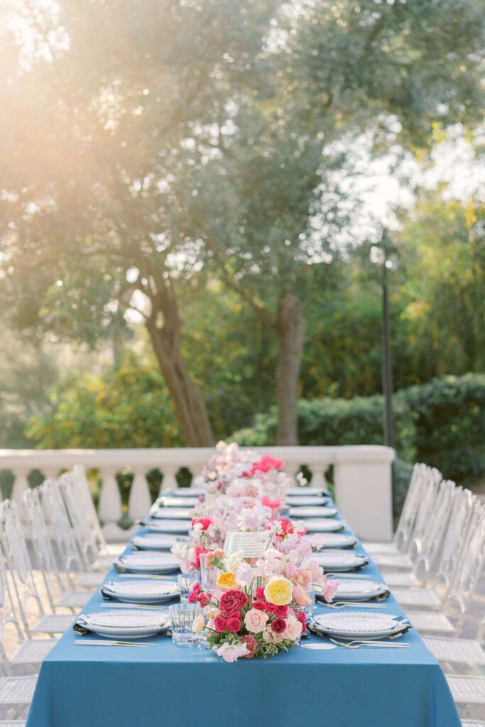 Blue wedding table with fushia flowers at castel bay