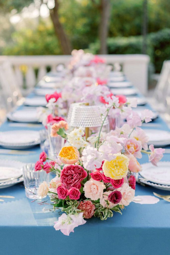 Blue wedding table with fushia flowers at castel bay