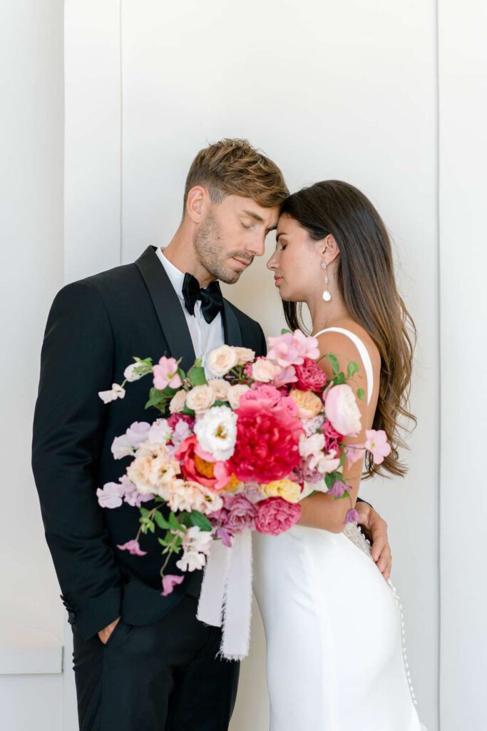 Bride and groom portrait with a pink bouquet