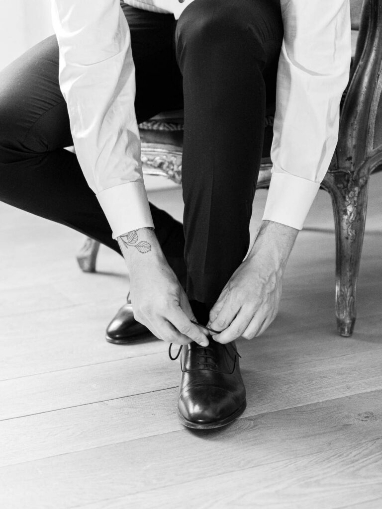 groom lacing his shoes