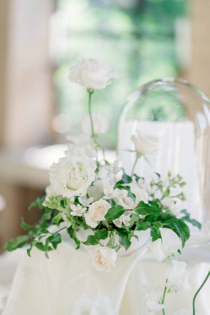 wedding seating chart with white silk tablecloth, white flowers and foliage