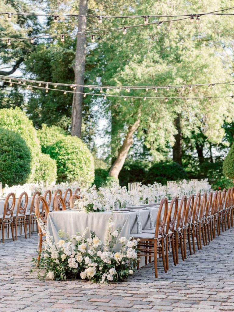 Wedding tables reception with grey tablecloth, white flowers and foliage at Château de Fontarèches