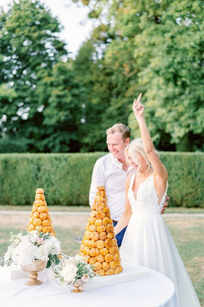 mariés découpant la pièce montée de chou - bride and groom cutting the croquembouche