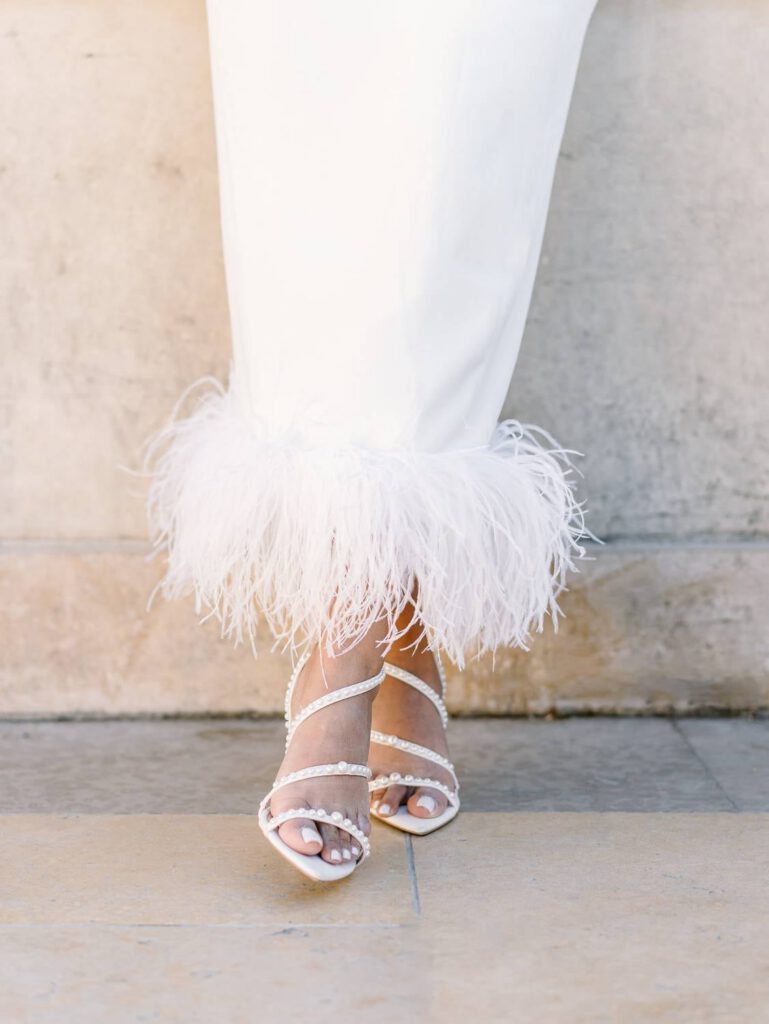 bride dress with feathers and white shoes