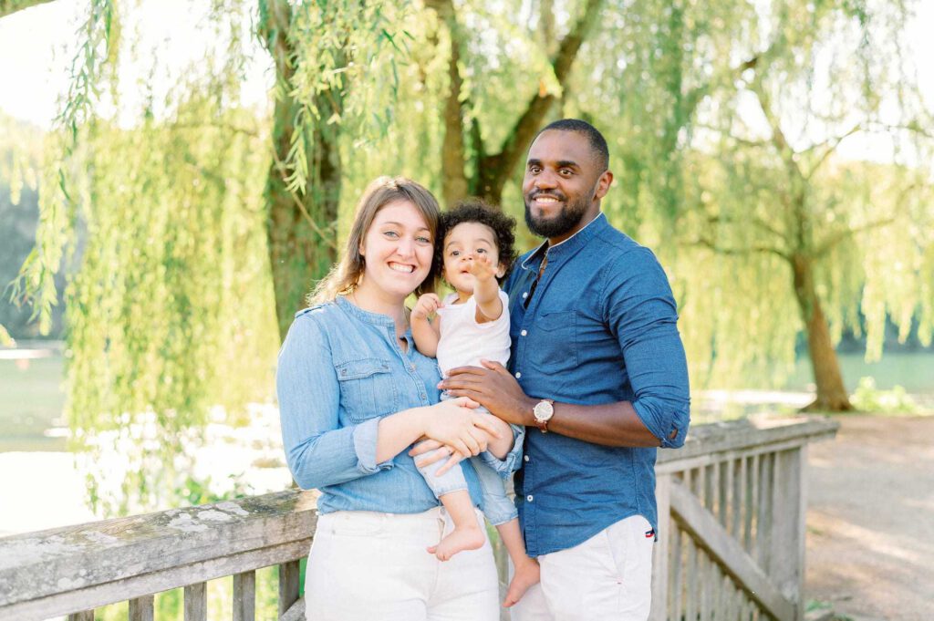 Photo de famille dans un parc avec les parents et leur enfant
