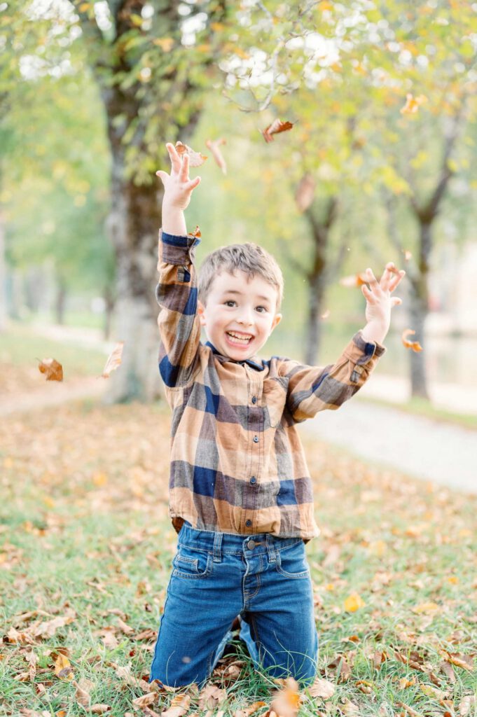 Un enfant joue avec des feuilles d'automne